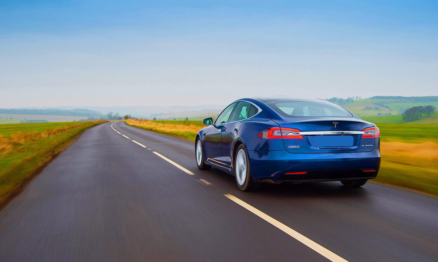 Blue Tesla Model S travelling along a road