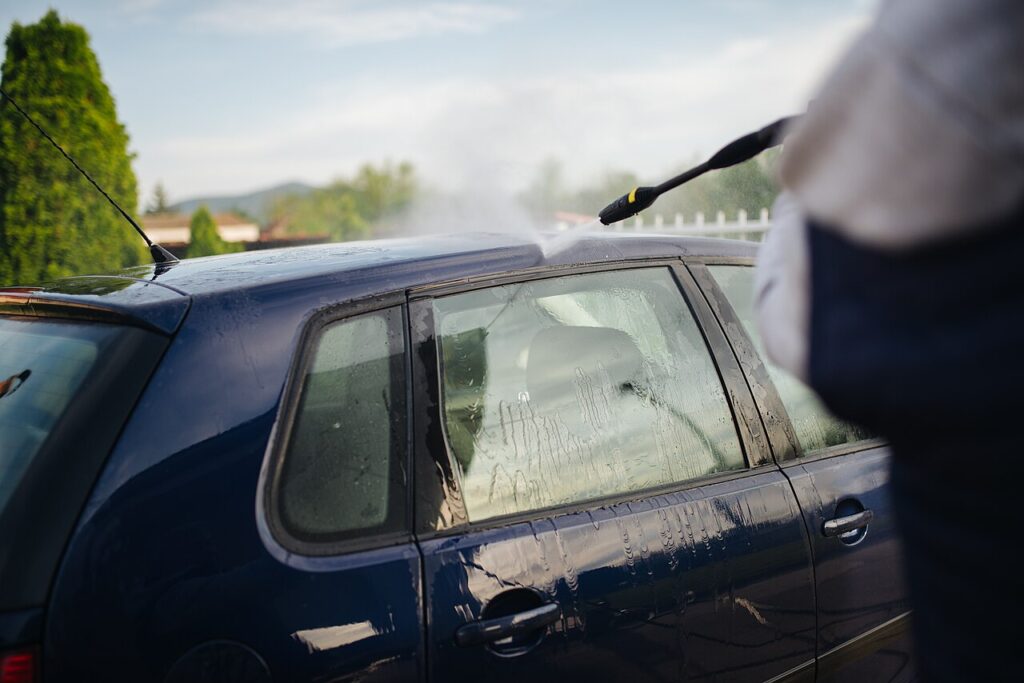 Blue car being washed outdoors
