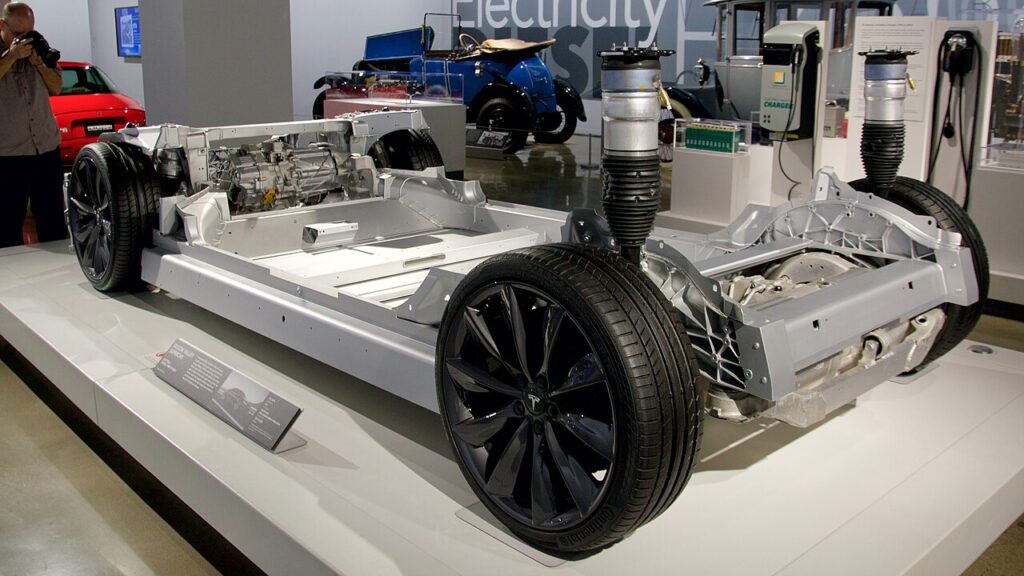 Exposed Tesla Model S chassis showing its separate drive assemblies and battery enclosure