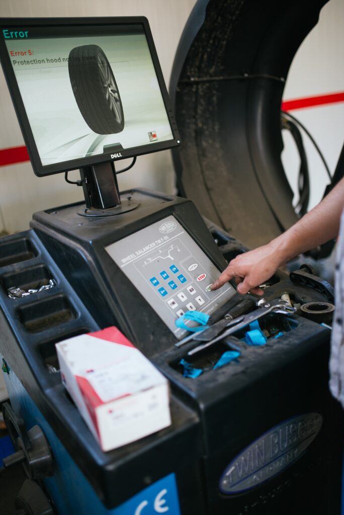 Operator using the controls of a wheel balancing machine
