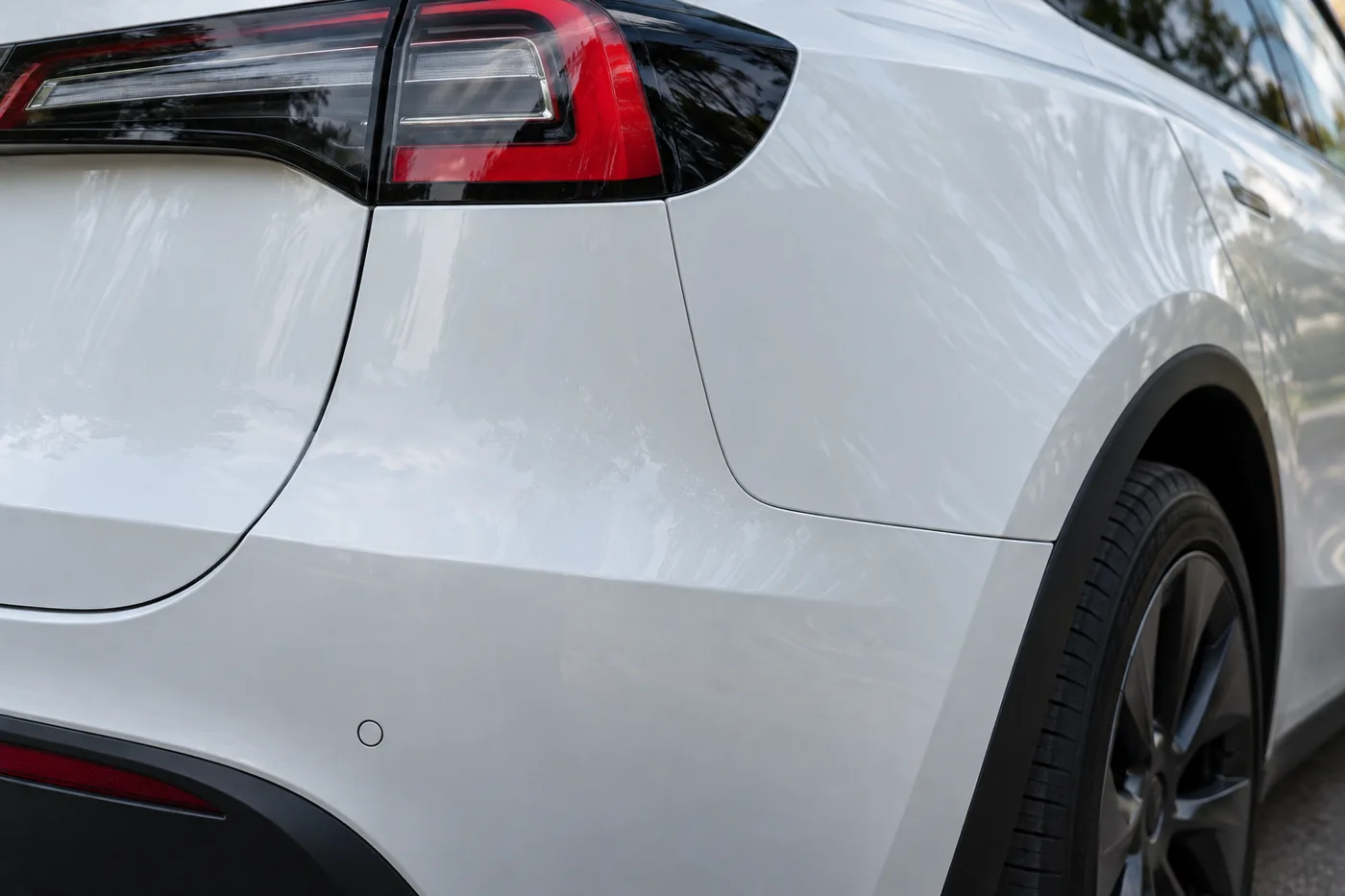 White Tesla rear bumper meeting the quarter panel and tail lamp