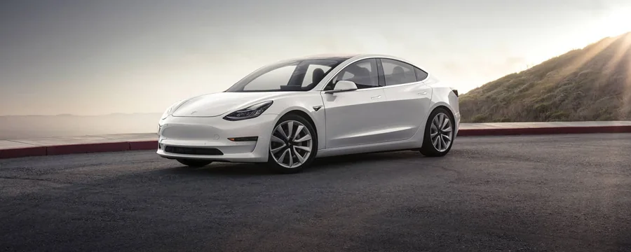 White Tesla Model 3 viewed from the front and side