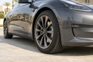 Front wheel and road tyre on a grey Tesla Model 3